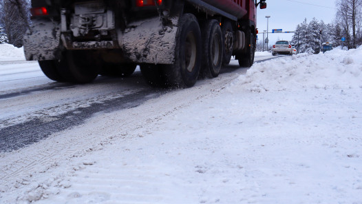 Rekka ajaa lumisella autotiellä.