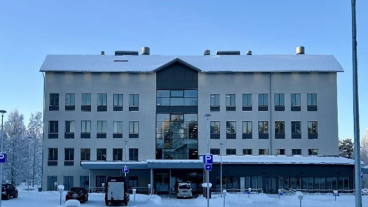 Talvinen Innocum toimistorakennus, jonka edessä on pysäköityjä autoja ja luminen piha.