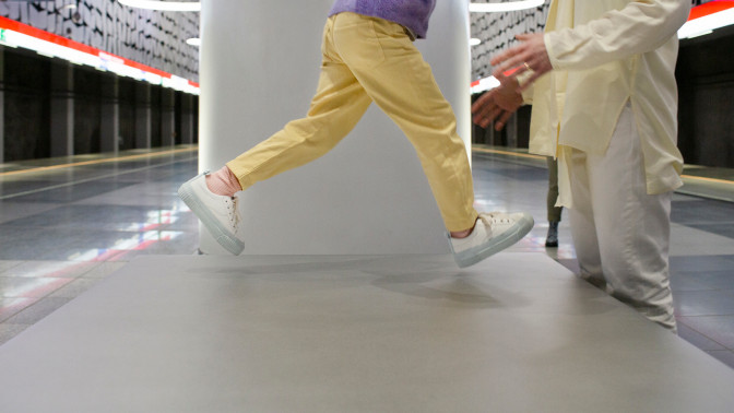 Lapsi hyppää aikuisen syliin metroasemalla.