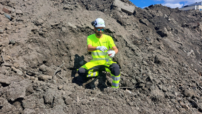 Sitowisen asiantuntija ottamassa näytettä Tampereen Takojankadun kaatopaikalta.