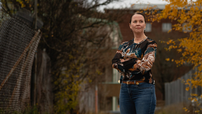 Sanna Härkönen seisoo kaupunkiympäristössä ruskan keskellä.