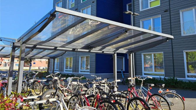 Polkupyöriä parkissa kerrostalon pihalla.