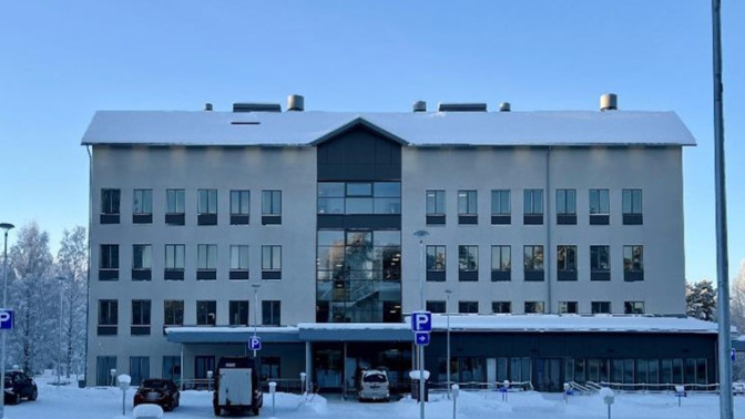 Talvinen Innocum toimistorakennus, jonka edessä on pysäköityjä autoja ja luminen piha.