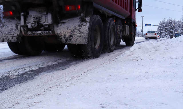 Kuorma-auto ajamassa lumisella tiellä