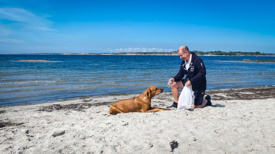 Johan och en hund på strand.