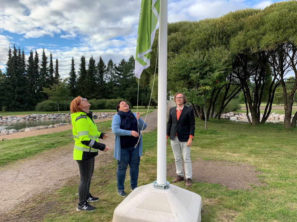 Paraisten kaupungin työntekijät nostavat Green Flag Award -lipun salkoon.