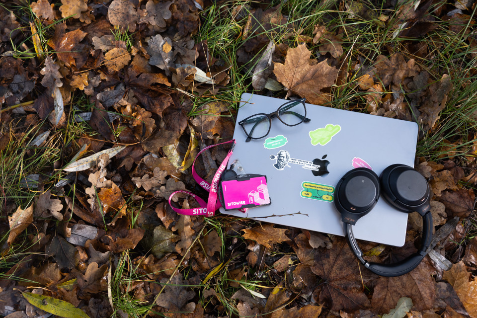 Tietokone ja kuulokkeet syksyisten lehtien päällä.