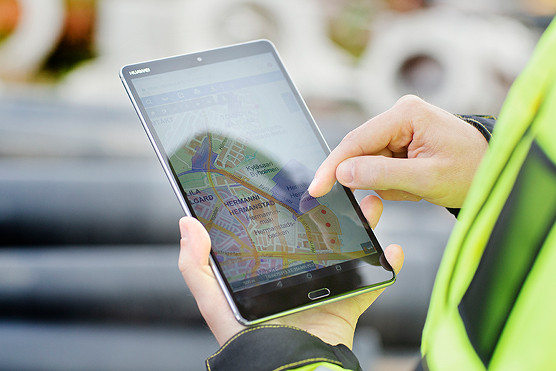 henkilö katsoo karttaa isosta tabletista