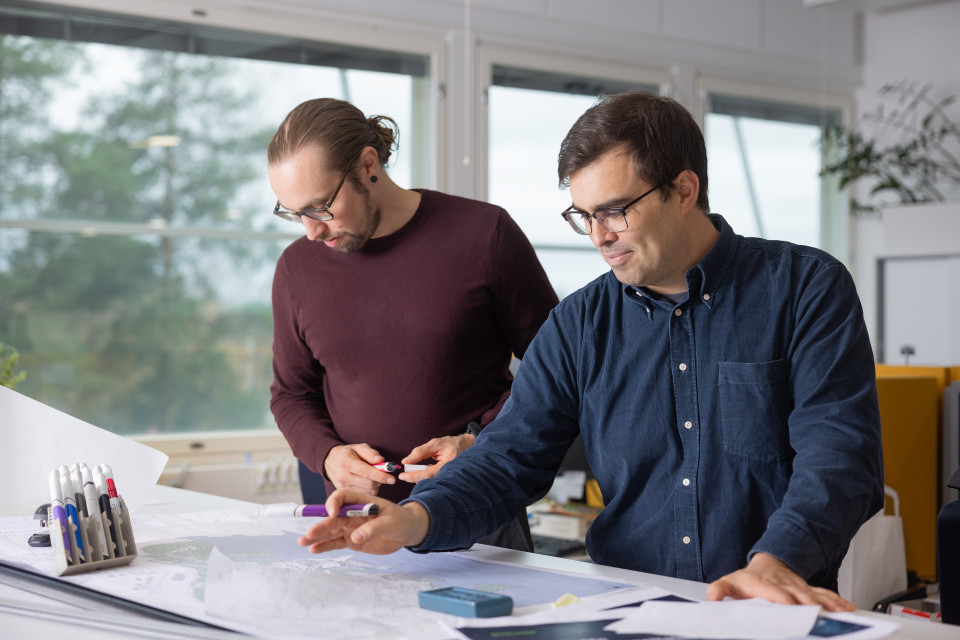 Sitowisen asiantuntijat suunnittelupöydän ääressä.