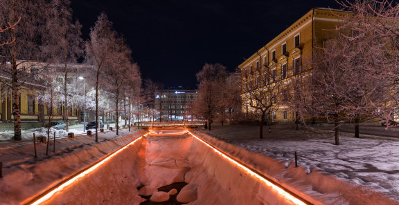 Kuvassa näkyy Oulun kaupungiojan valaistus pimeällä.