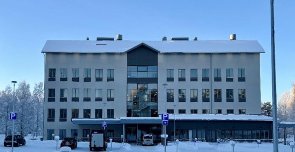 Talvinen Innocum toimistorakennus, jonka edessä on pysäköityjä autoja ja luminen piha.