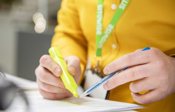 henkilö piirtää paperiin 