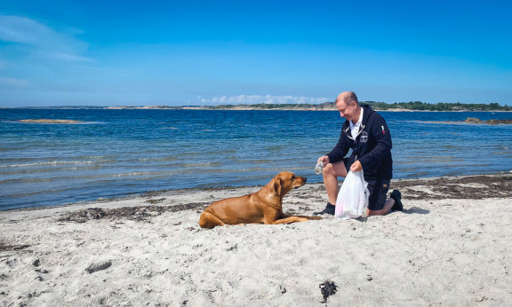 Johan och en hund på strand.