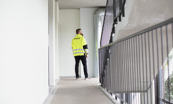 Sitowisen asiantuntija kerrostalon rappukäytävässä.