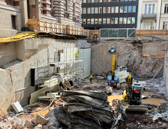 Kuva työmaasta, missä katu on kaivettu auki keskustan arvokiinteistöjen välissä.