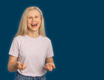 Sitowiseläinen vaaleassa t-paidassa osoittaa käsillään sinisellä taustalla.